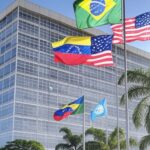 Edifício do Itamaraty em Brasília com bandeiras do Brasil, Venezuela, EUA e ONU, representando condenação ao bloqueio naval contra Venezuela.