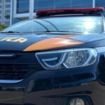 Viatura da Polícia Federal em frente a prédio de banco no Brasil, representando investigação de fraudes na venda do Banco Master.