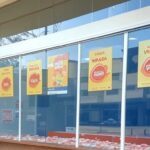 Casa lotérica em Goiânia celebrando vitórias na Mega da Virada, com bilhetes e cartazes, sonhando com prêmios em 2025.