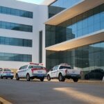 Fachada de hospital em Brasília com viaturas policiais, ilustrando suspeita de mortes em unidade de saúde no DF.