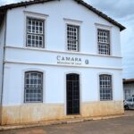 Fachada da Câmara Municipal de Urutaí com viatura policial, representando indiciamento de vereador por estupro.