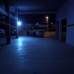 Espaço de festas vazio em Hidrolândia com fita de isolamento policial e viaturas após tiroteio.