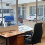 Delegacia em Anápolis com viatura policial e computador de IA, representando prisão por crime cibernético.