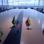 Sala de reuniões no Palácio do Planalto com bandeiras do Brasil, EUA e Venezuela, representando reunião emergencial após ataque à Venezuela.