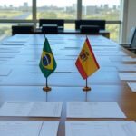 Mesa diplomática com bandeiras do Brasil e Espanha, documentos de acordo Mercosul-UE e mapa da Venezuela em Brasília.