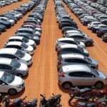 Pátio com veículos apreendidos para leilão online do TJ-GO em Goiás, incluindo carros e motos alinhados.