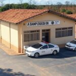 Fachada de delegacia de polícia em Serranópolis, Goiás, com viaturas policiais, representando prisão por tentativa de homicídio.