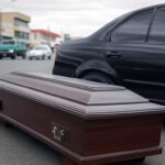 Caixão caído de carro funerário na Avenida Brasil Sul em Anápolis, Goiás, em cena urbana brasileira.