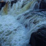 Cachoeira em Aragoiânia, Goiás, com águas correndo sobre rochas, local de afogamento de jovem colombiano.