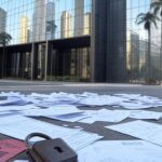Edifício bancário em São Paulo com símbolos de fraude financeira, representando alerta sobre maior fraude bancária no Brasil.