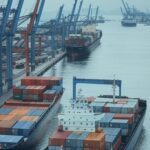 Porto brasileiro com navios de carga simbolizando comércio Brasil-Irã e impacto de sanções dos EUA.