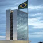 Congresso Nacional em Brasília com bandeira a meio mastro, simbolizando luto por legado político brasileiro.