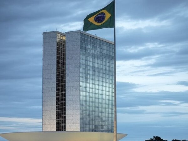 Congresso Nacional em Brasília com bandeira a meio mastro, simbolizando luto por legado político brasileiro.