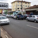 Rua em Anápolis com placa de contramão e viatura policial, representando incidente de agressão após direção irregular.
