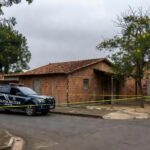 Viatura da Polícia Militar em rua de Goiânia, com fita de isolamento em cena de feminicídio.