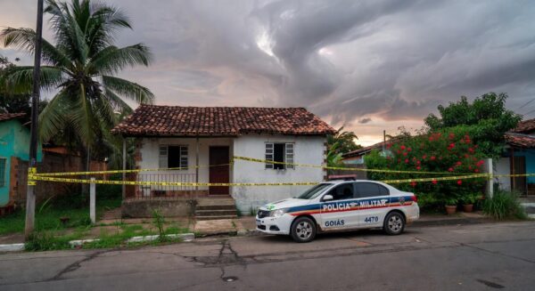 Casa em Jataí isolada por fita policial e viatura da PM, representando cena de crime após separação violenta.